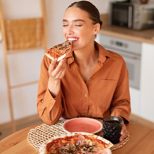 Woman enjoying meal in kitchen at home