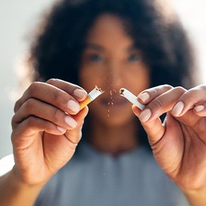 Closeup of woman breaking cigarette