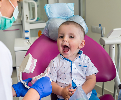 Toddler opening their mouth wide in the dental chair