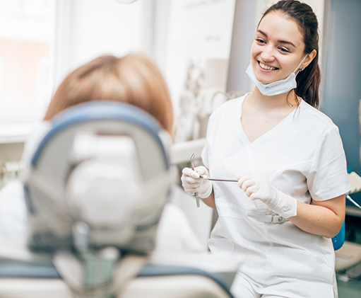 Dentist smiling at a patient in the dental chair