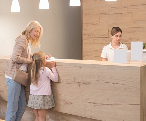 Woman and her young daughter checking in at the front desk