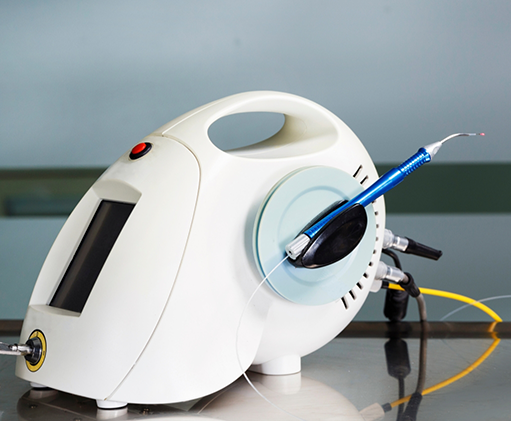 Small round white machine attached to a pen like dental laser device
