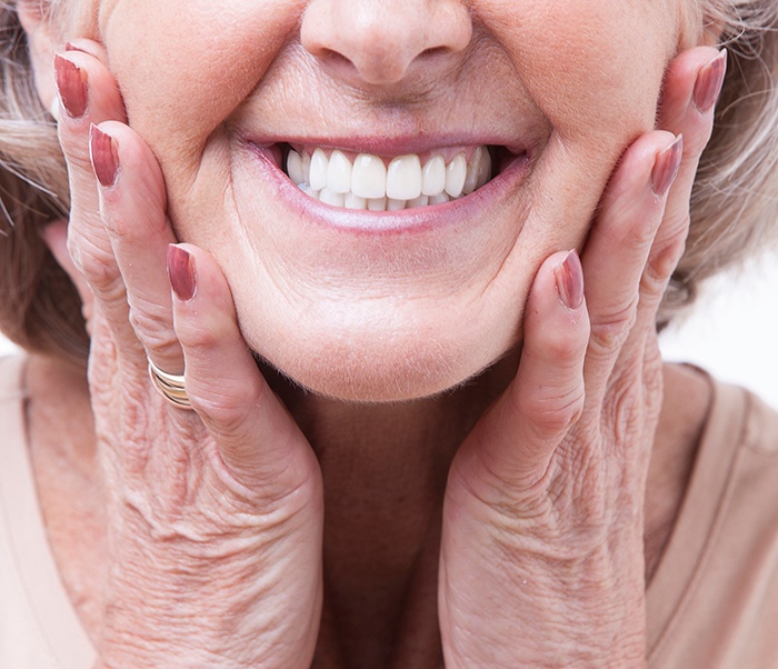 a patient with dentures smiling confidently 