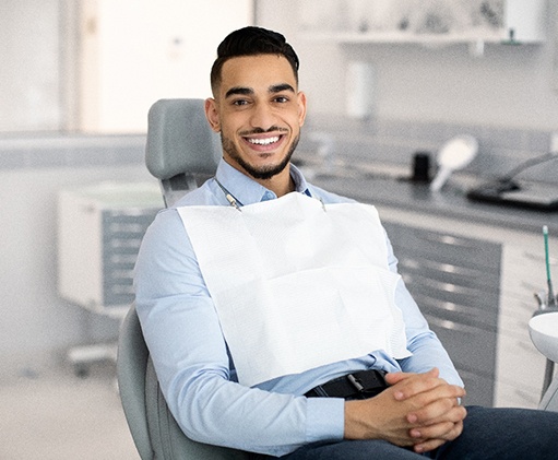 Patient smiling while sitting in treatment chair