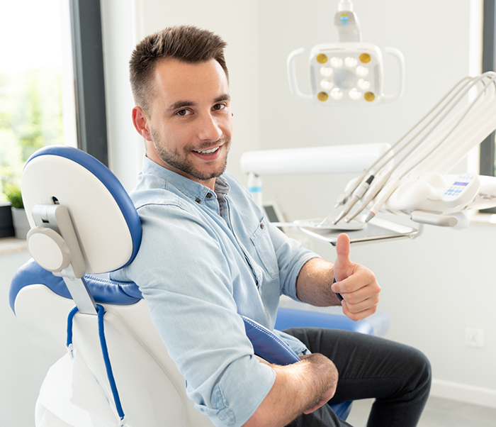Smiling man giving a thumbs up in the dental chair