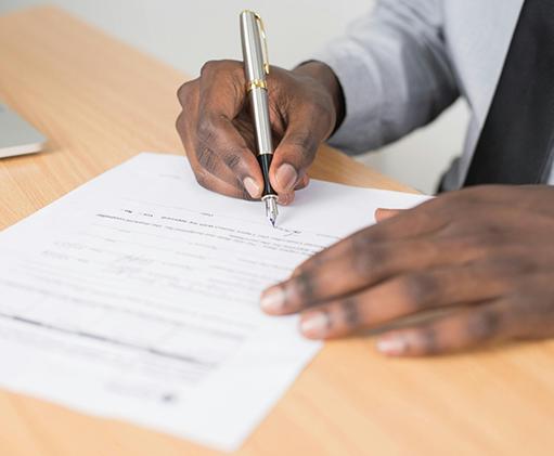Person filling out paperwork at a table