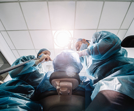 Dentist and assistant performing gum disease treatment on a patient