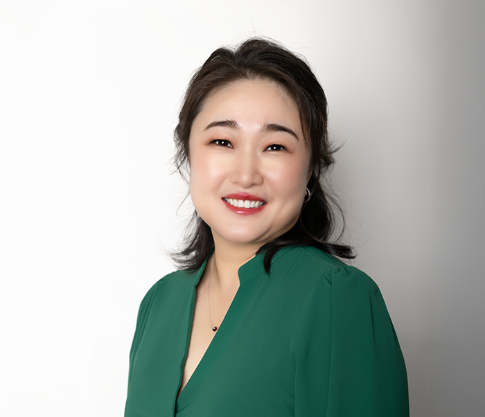 Justin dentist Doctor Hui Zhang smiling in a green blouse