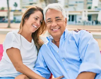 Older couple sitting outside and smiling