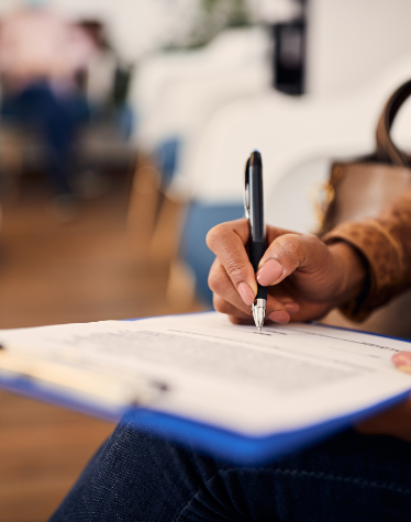 Justin dental patient filling out paperwork on a clipboard