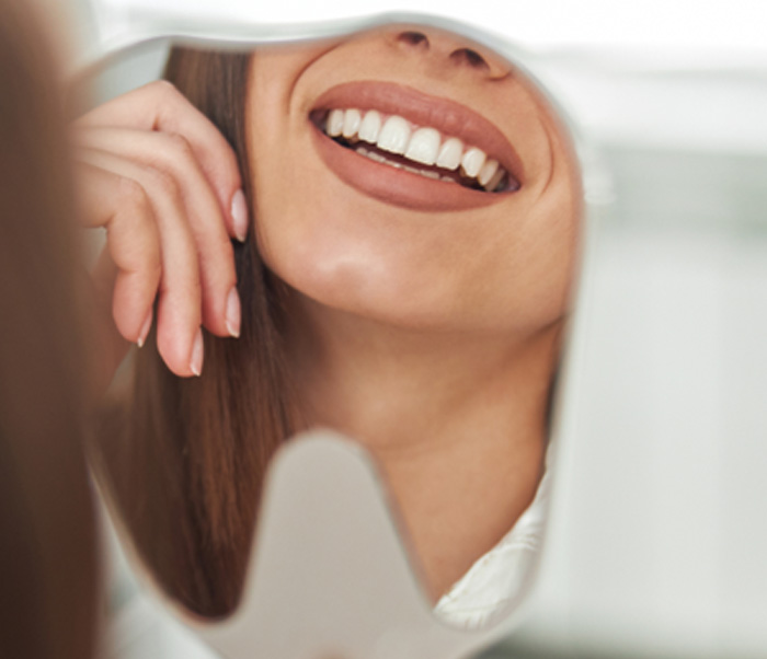 Patient’s beautiful smile reflected in mirror