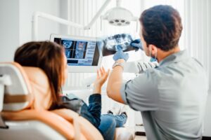 Dentist and patient looking at X-ray.