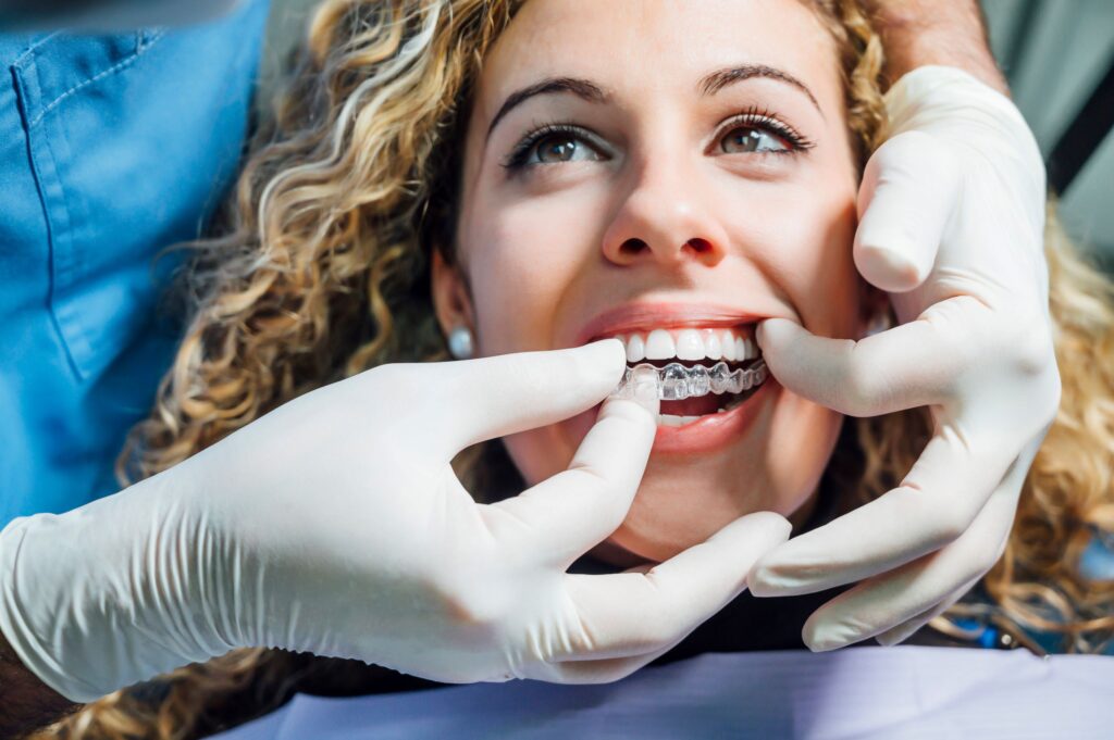 Dentist placing Invisalign over patient's top arch